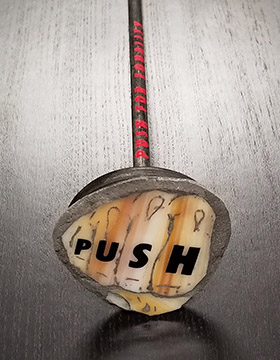 Push plate with glass mosaic of a fist and the word PUSH tattooed on the fingers attached to piston that moves the mobile
