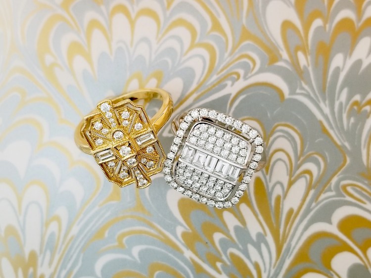 Two engagement rings, art deco diamond in gold and white gold on a gold, silver, and white Turkish watercolor background.
